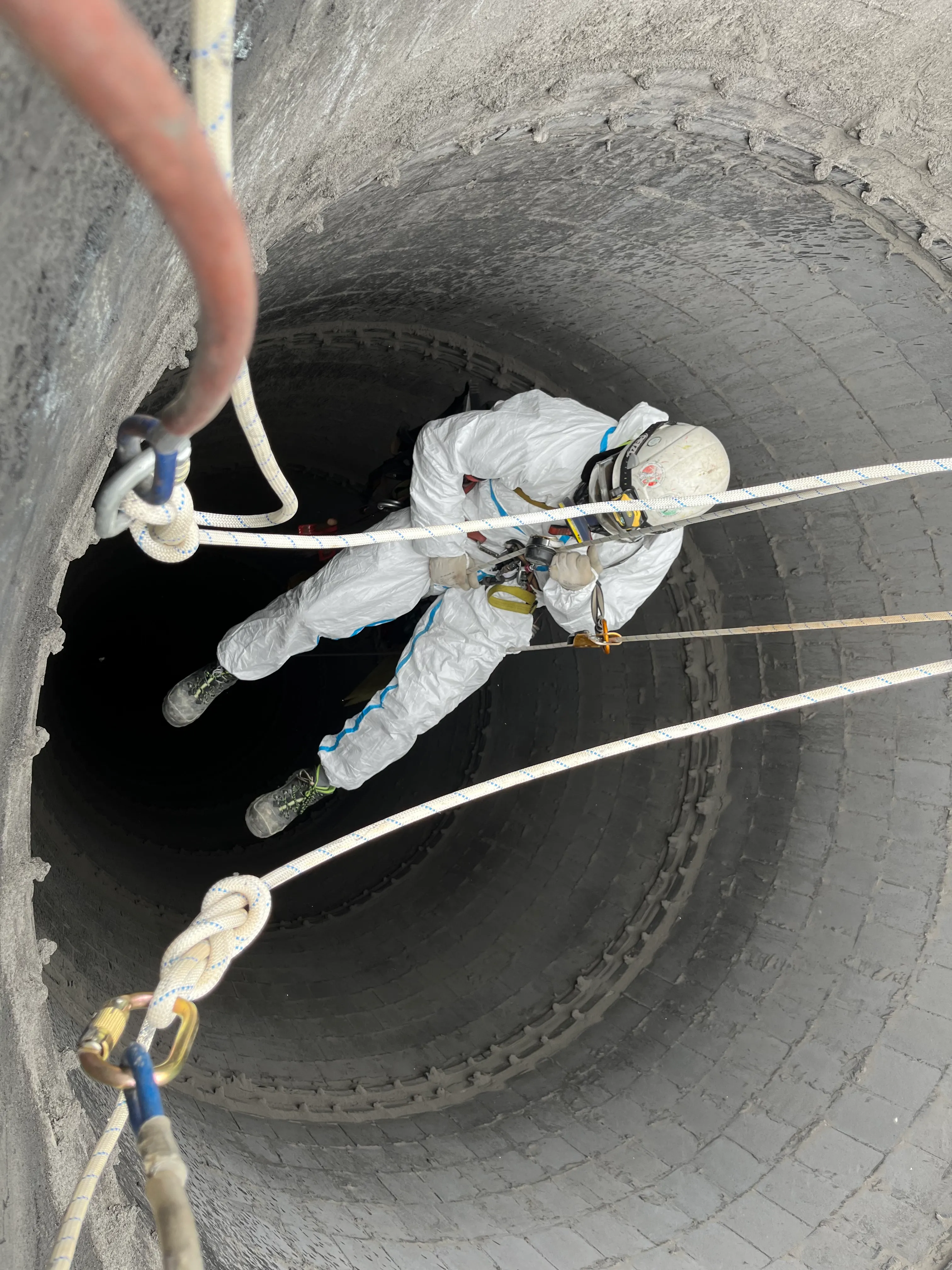 Zdjęcie przedstawia alpinistę przemysłowego podczas pracy na wysokości.