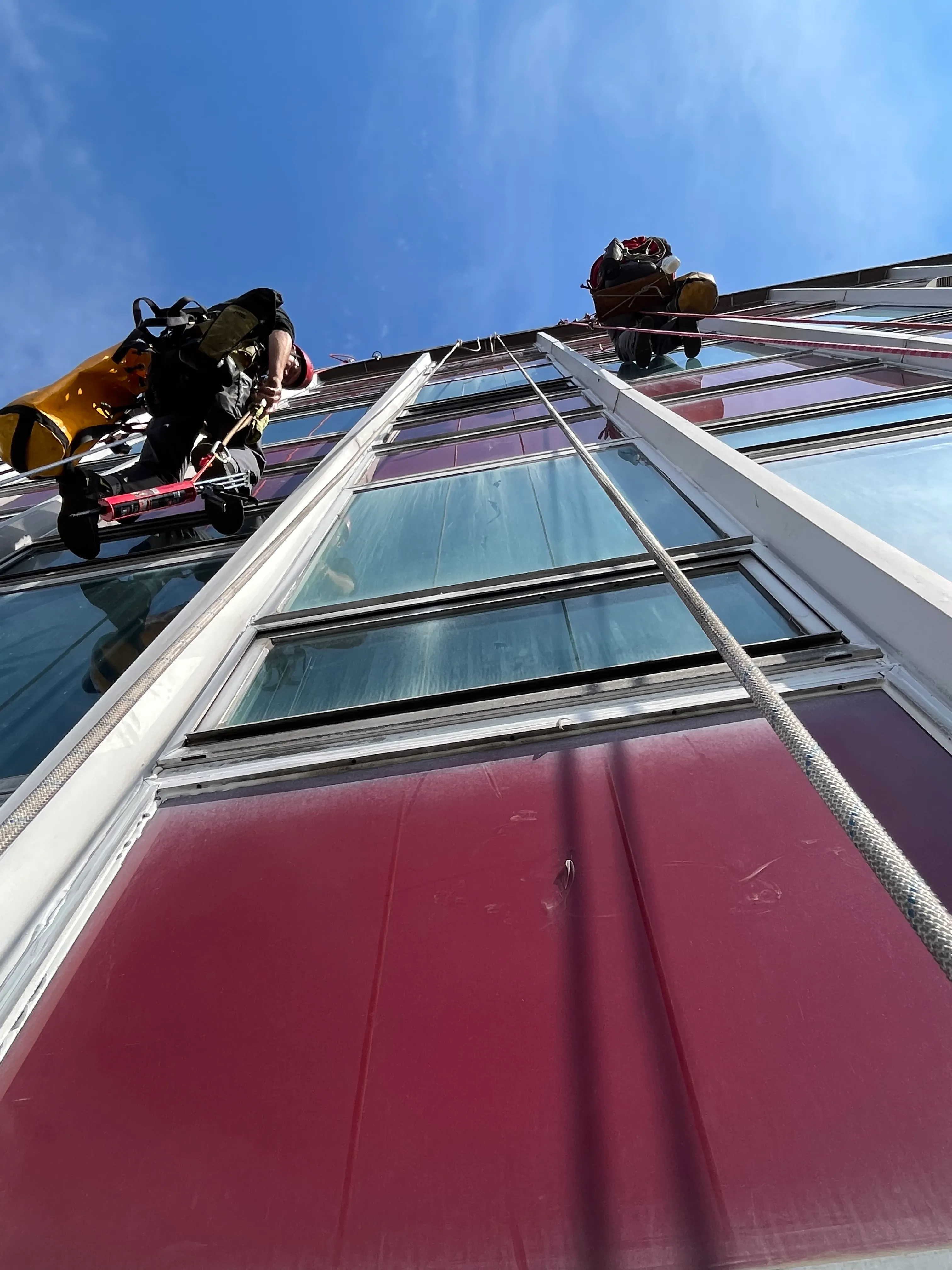 Zdjęcie przedstawia alpinistę przemysłowego podczas pracy na wysokości.